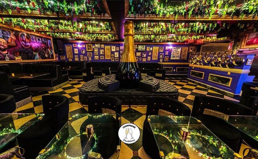 Champagne Problems lounge with patterned carpet and golden lighting